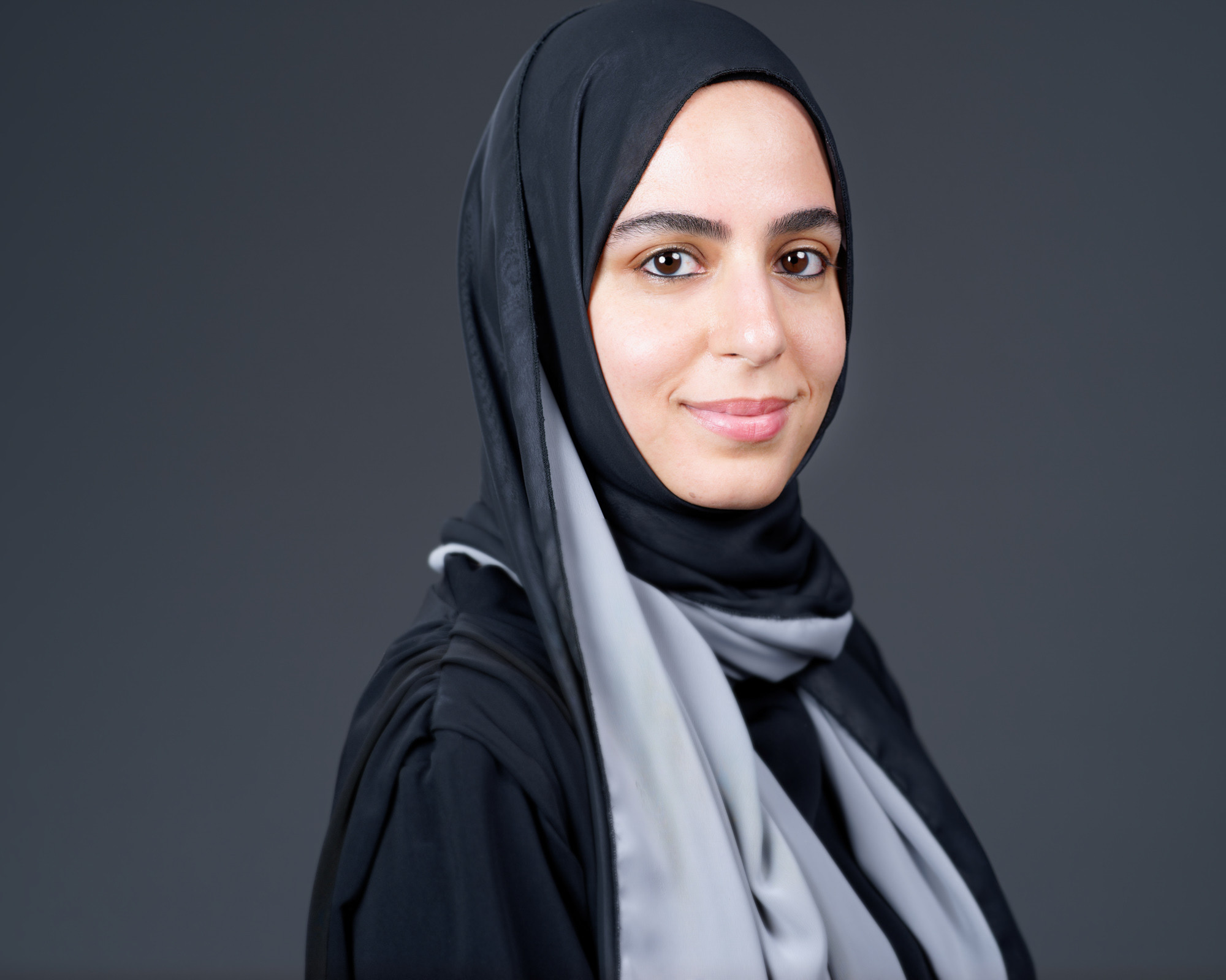 Studio portrait of a woman wearing a black and gray headscarf